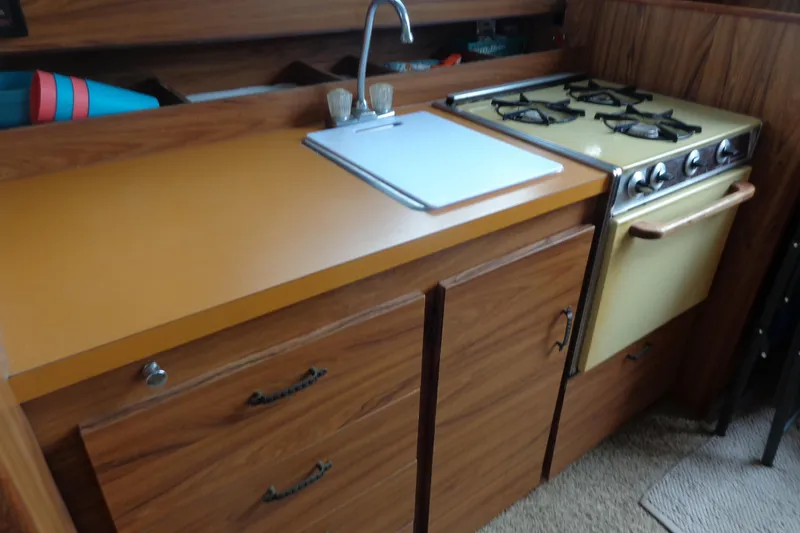 Slide: The Image of Vintage 1976 Tolly sedan kitchen with wood cabinets, yellow countertop, and retro stove. - 7