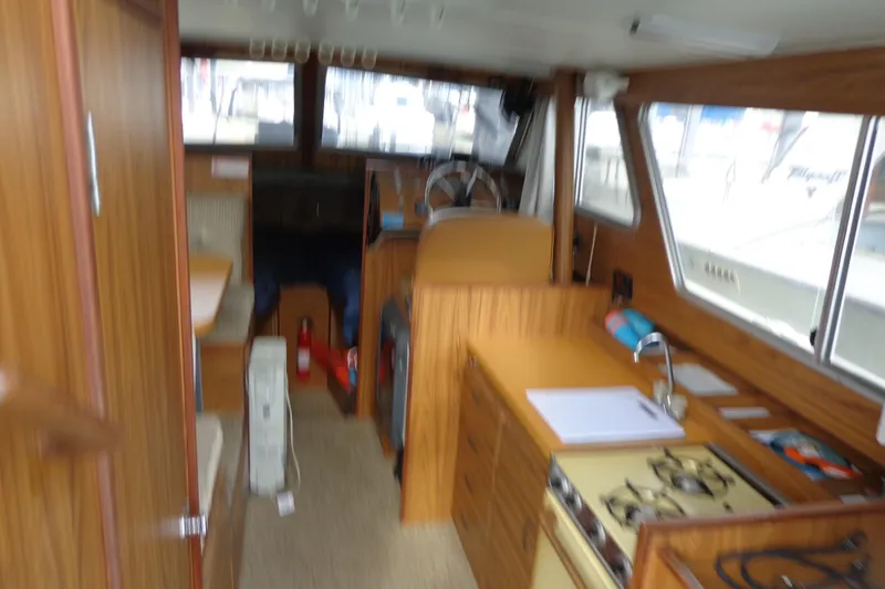 Slide: The Image of Interior of a 1976 Tolly sedan boat with wood paneling and kitchen area. - 8