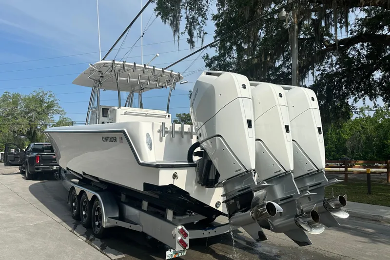 Slide: The Image of 2024 Contender 39 ST fishing boat deck with rod holders and Mercury engines. - 15