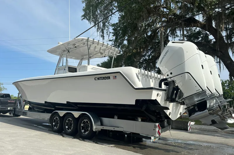 Slide: The Image of 2024 Contender 39 ST boat on trailer at event venue, featuring sleek design and modern amenities. - 16