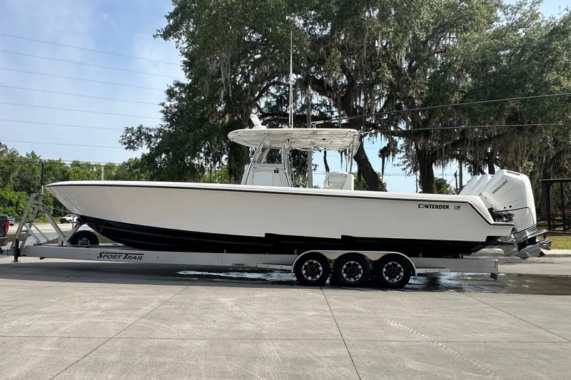 Slide: The Image of 2024 Contender 39 ST boat interior with modern console and seating in a parking lot. - 17