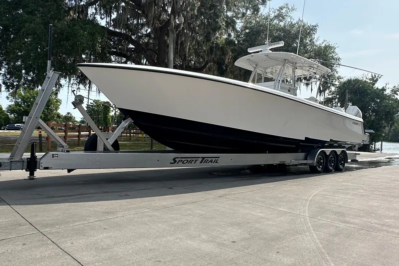 Slide: The Image of 2024 Contender 39 ST boat interior with seating, steering wheel, and triple Mercury engines. - 19