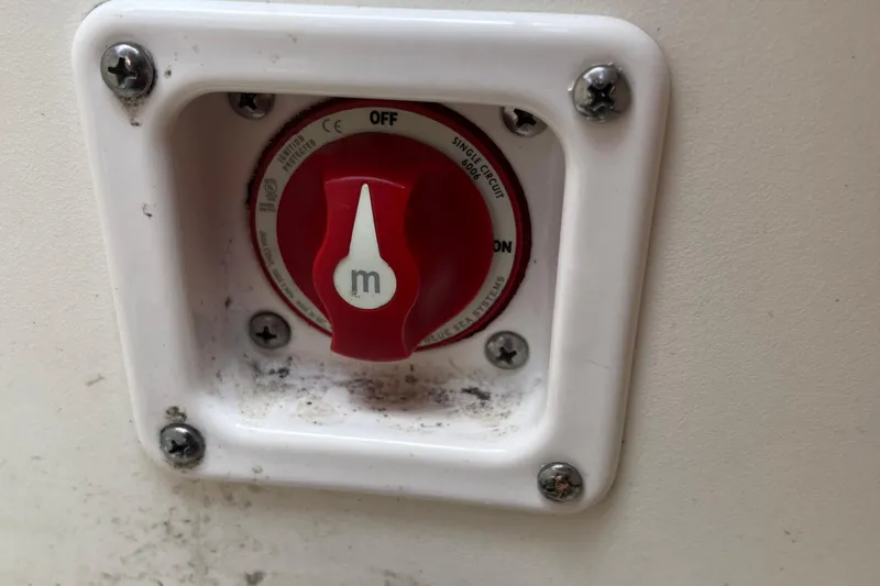 Slide: The Image of Red battery switch on a 2021 Chaparral 21 SSi boat, mounted on a white panel. - 6