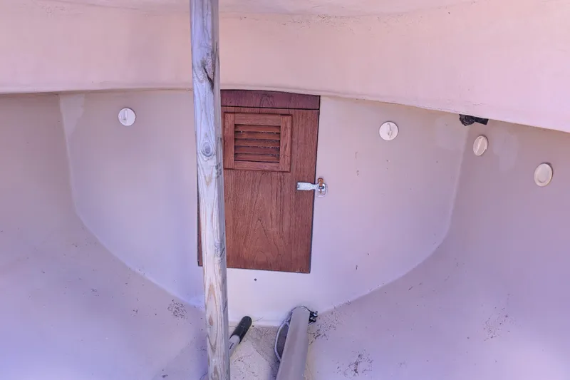 Slide: The Image of Interior view of a 1981 Cape Dory Typhoon sailboat with wooden door and white walls. - 4