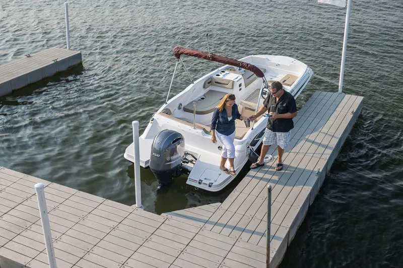 Slide: The Image of Couple enjoying a 2025 Hurricane SunDeck Sport 205 OB boat at a scenic dock. - 32