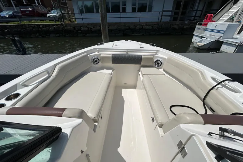 Slide: The Image of 2022 Cobia 240 Dual Console boat interior with white seating and cup holders. - 10