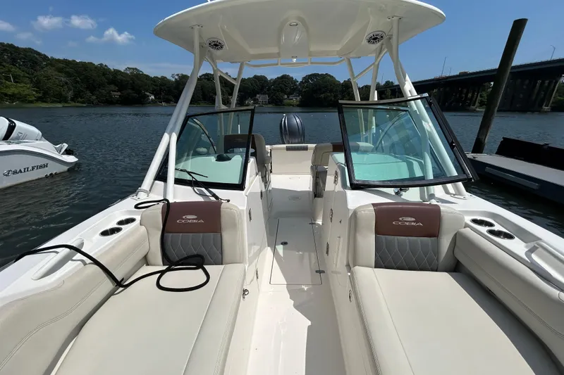 Slide: The Image of 2022 Cobia 240 Dual Console boat on water, featuring spacious seating and modern design. - 11