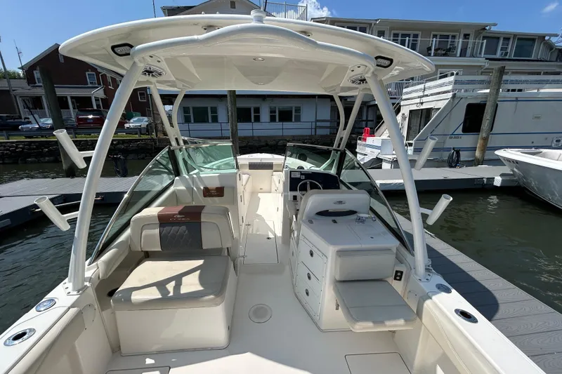 Slide: The Image of 2022 Cobia 240 Dual Console boat docked, featuring spacious seating and modern design. - 12