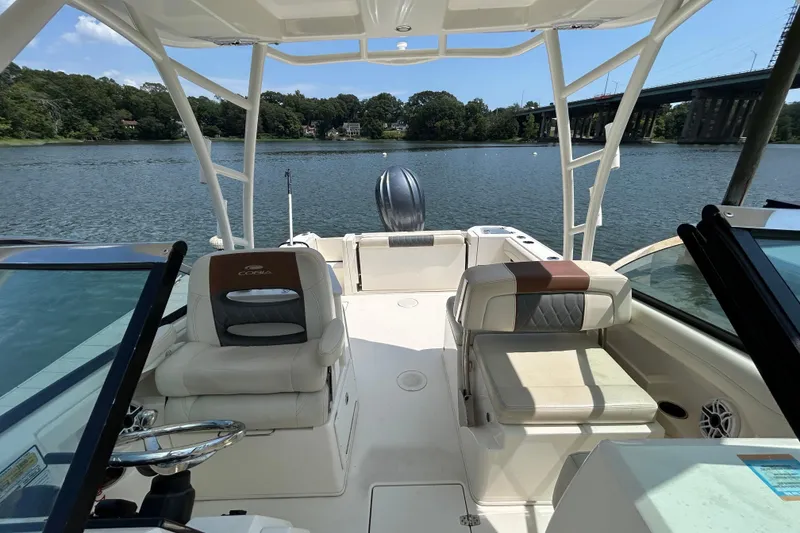 Slide: The Image of 2022 Cobia 240 Dual Console boat interior on a scenic river with bridge view. - 13