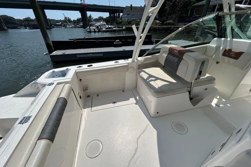 Slide: The Image of 2022 Cobia 240 Dual Console boat interior with seating, docked by the water. - 15