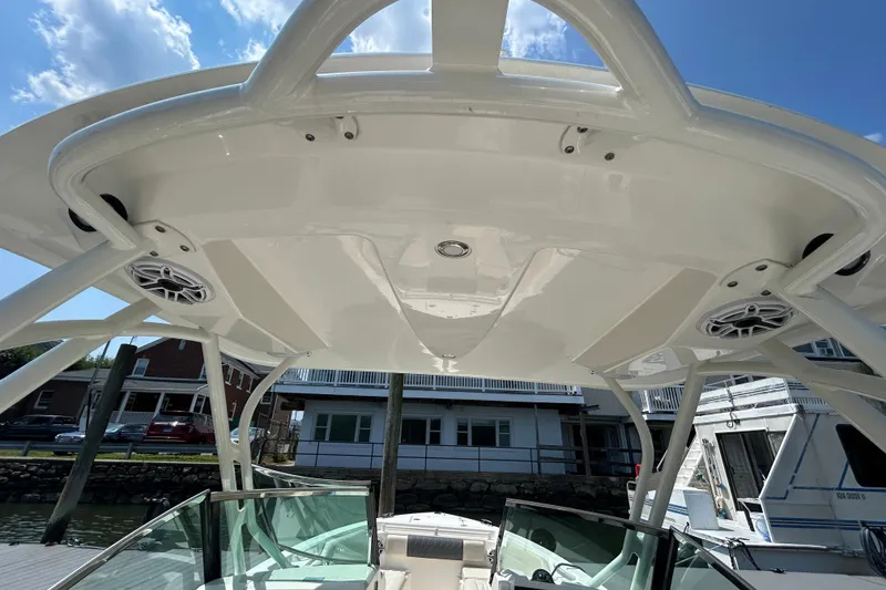 Slide: The Image of 2022 Cobia 240 Dual Console boat with sleek white hardtop and integrated speakers. - 9