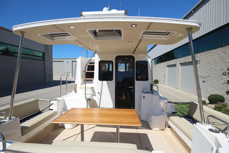 Slide: The Image of 2020 Ranger Tugs R-31 Command Bridge LE, spacious deck with seating and table. - 21