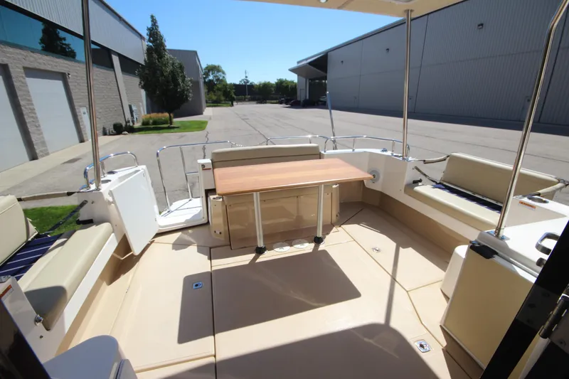 Slide: The Image of 2020 Ranger Tugs R-31 Command Bridge LE interior with seating and table, docked outdoors. - 24