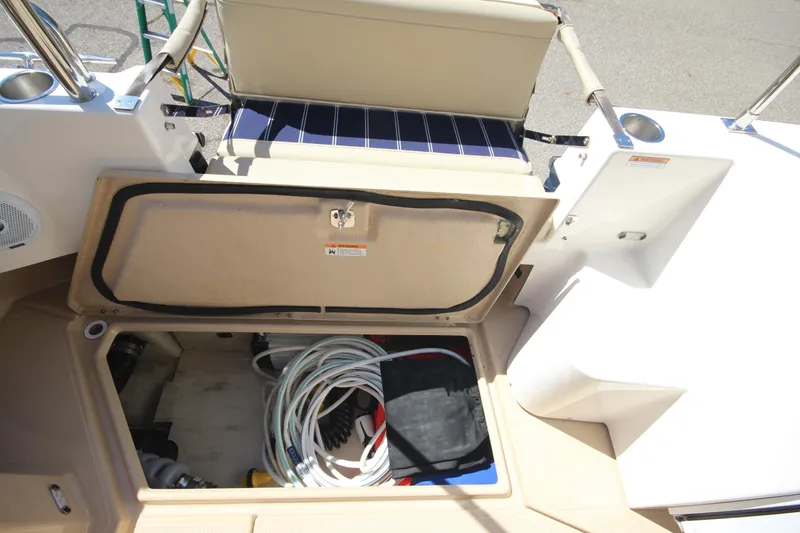 Slide: The Image of 2020 Ranger Tugs R-31 Command Bridge LE storage compartment with coiled cables and accessories. - 27