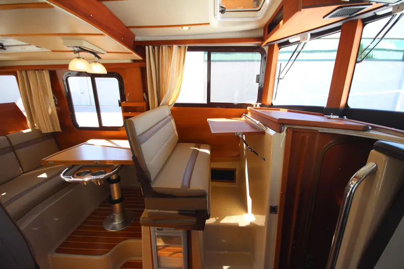 Slide: The Image of 2020 Ranger Tugs R-31 Command Bridge LE interior with dining area and wood accents. - 39