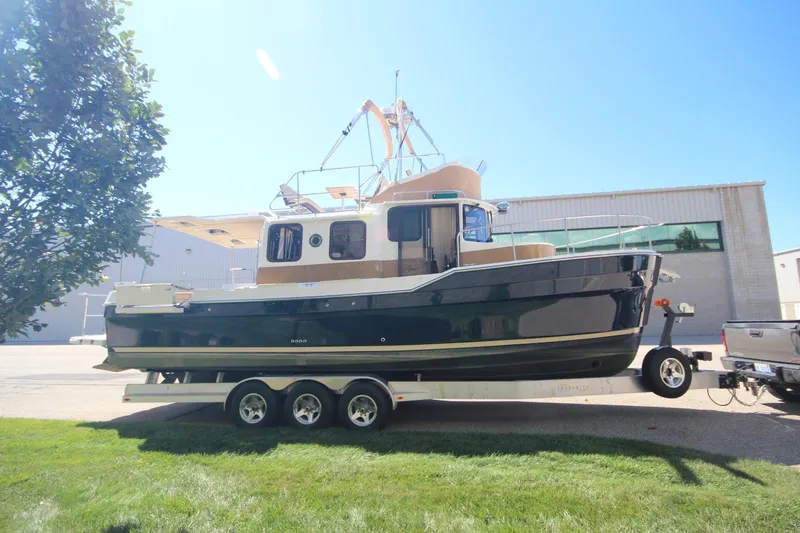 Slide: The Image of 2020 Ranger Tugs R-31 Command Bridge LE on trailer, parked outdoors. - 4