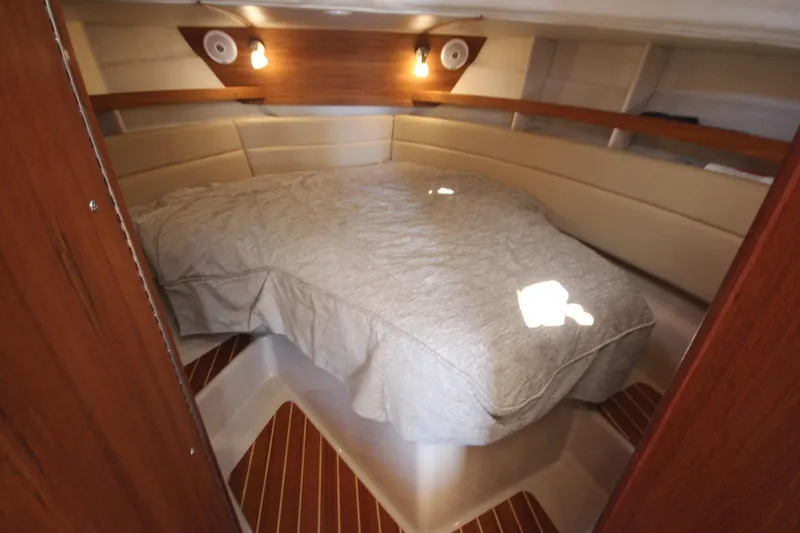 Slide: The Image of 2020 Ranger Tugs R-31 Command Bridge LE cabin interior with cozy bed and warm lighting. - 45