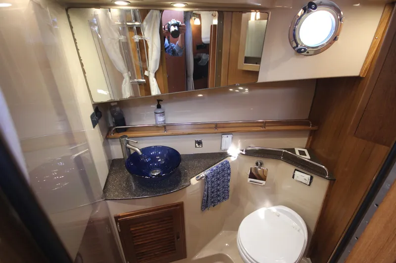 Slide: The Image of 2020 Ranger Tugs R-31 Command Bridge LE bathroom with modern sink and porthole window. - 48