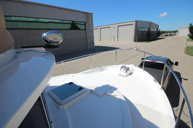 Slide: The Image of 2020 Ranger Tugs R-31 Command Bridge LE on trailer, parked near industrial buildings. - 50