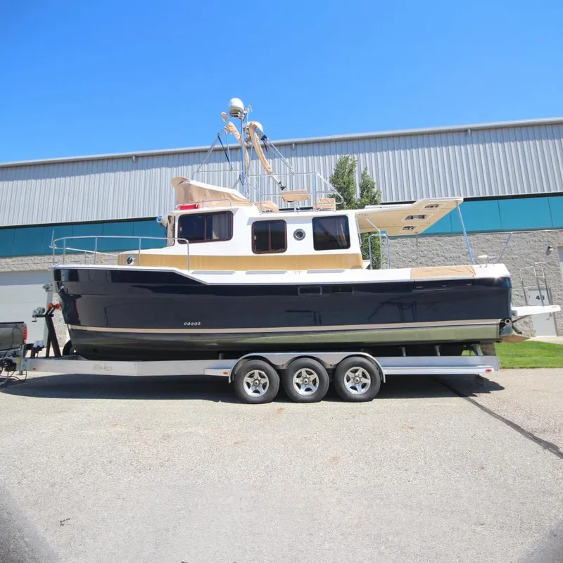 The Image of 2020 Ranger Tugs R-31 Command Bridge LE on trailer, parked outdoors. - 0