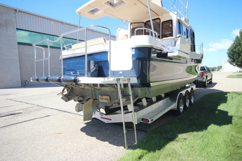 Slide: The Image of 2020 Ranger Tugs R-31 Command Bridge LE on trailer, parked outdoors. - 10