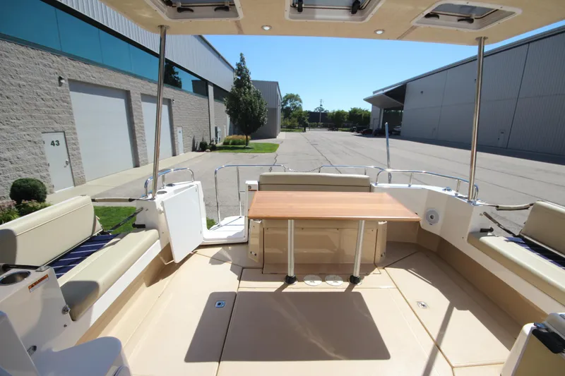 Slide: The Image of 2020 Ranger Tugs R-31 Command Bridge LE interior with seating and table, docked outdoors. - 25