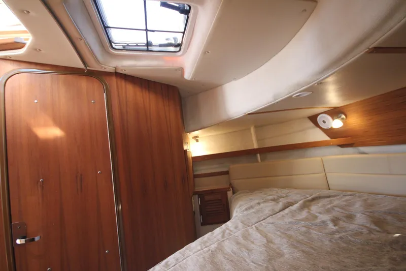 Slide: The Image of 2020 Ranger Tugs R-31 Command Bridge LE cabin interior with wood paneling and bed. - 46