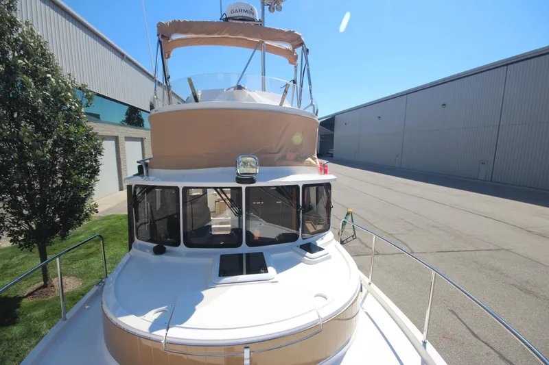 Slide: The Image of 2020 Ranger Tugs R-31 Command Bridge LE with trailer, docked near industrial buildings. - 53