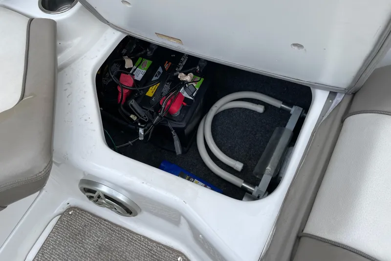 Slide: The Image of 2009 Yamaha Boats 232 Limited S battery compartment with wiring and storage space. - 17