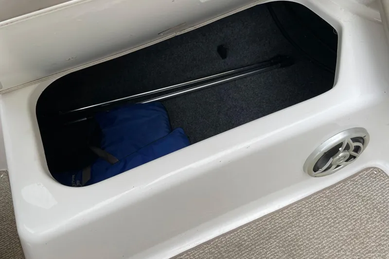 Slide: The Image of Storage compartment in a 2009 Yamaha Boats 232 Limited S, featuring a blue life jacket. - 18