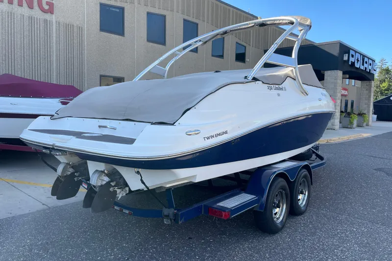 Slide: The Image of 2009 Yamaha Boats 232 Limited S on trailer, covered, parked outside dealership. - 7