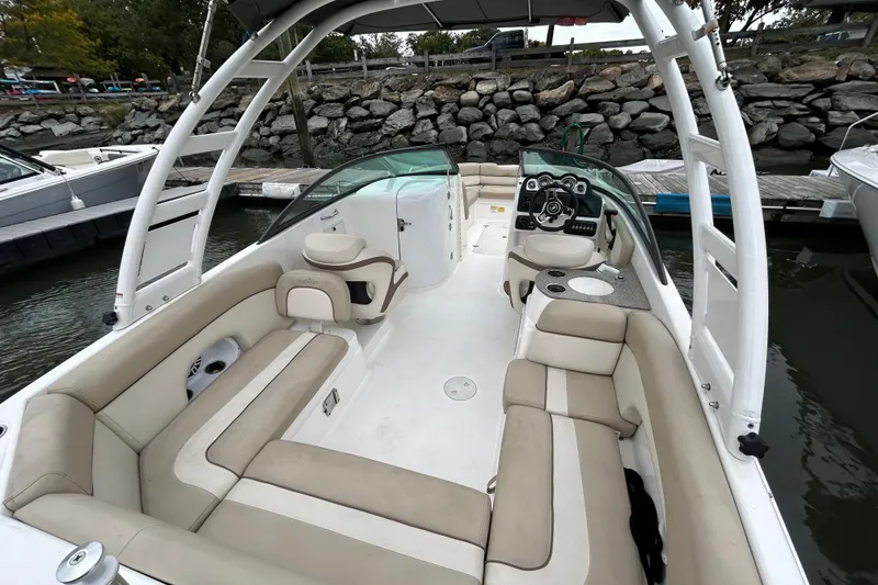 Slide: The Image of 2022 NauticStar 243 DC boat interior with beige seating and modern dashboard. - 11