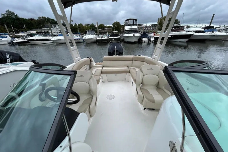 Slide: The Image of 2022 NauticStar 243 DC boat interior with seating, docked at marina. - 13