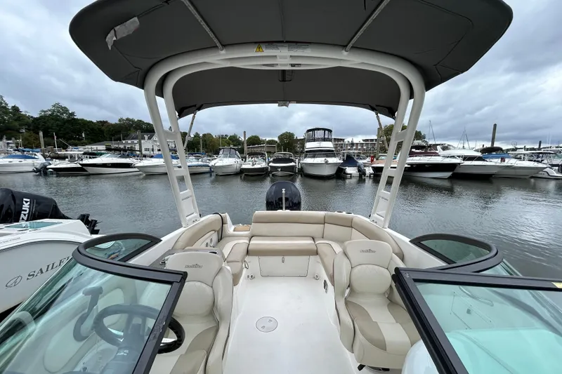 Slide: The Image of 2022 NauticStar 243 DC boat docked in a marina, surrounded by other boats. - 14