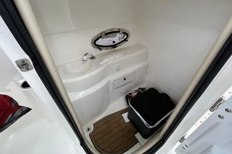 Slide: The Image of 2022 NauticStar 243 DC boat interior with sink and storage area. - 19
