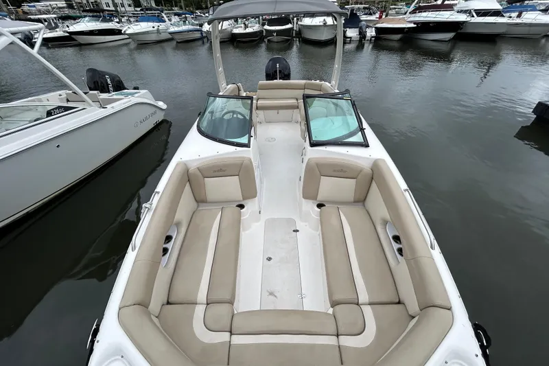 Slide: The Image of 2022 NauticStar 243 DC boat with spacious seating, docked among other boats. - 6
