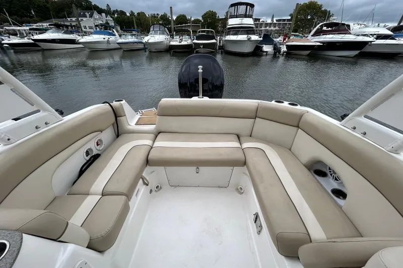 Slide: The Image of 2022 NauticStar 243 DC boat interior with beige seating, docked among other boats. - 9