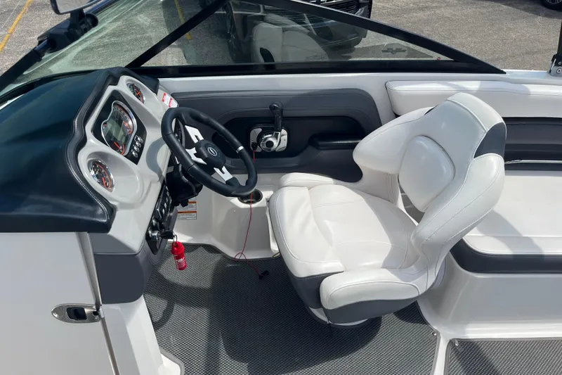 Slide: The Image of 2015 Chaparral Vortex 223 VRX boat interior with steering wheel and white captain's chair. - 11