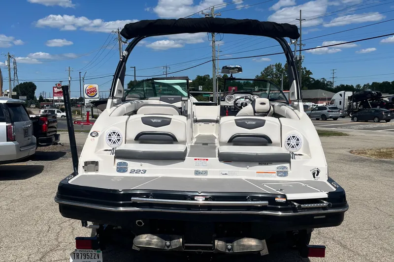 Slide: The Image of 2015 Chaparral Vortex 223 VRX boat, rear view, parked in a lot under a clear sky. - 2