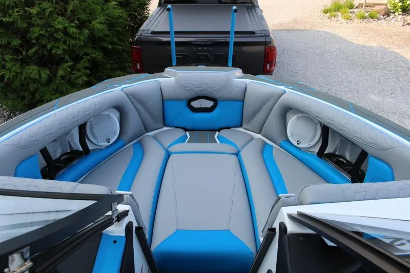 Slide: The Image of 2026 Centurion Ri 230 boat interior with blue and gray seating, featuring speakers. - 7