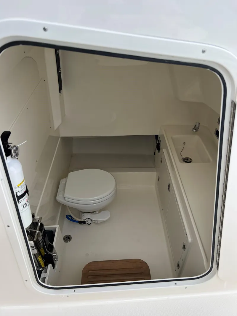 Slide: The Image of 2023 Boston Whaler 330 Outrage boat interior with toilet and sink. - 9