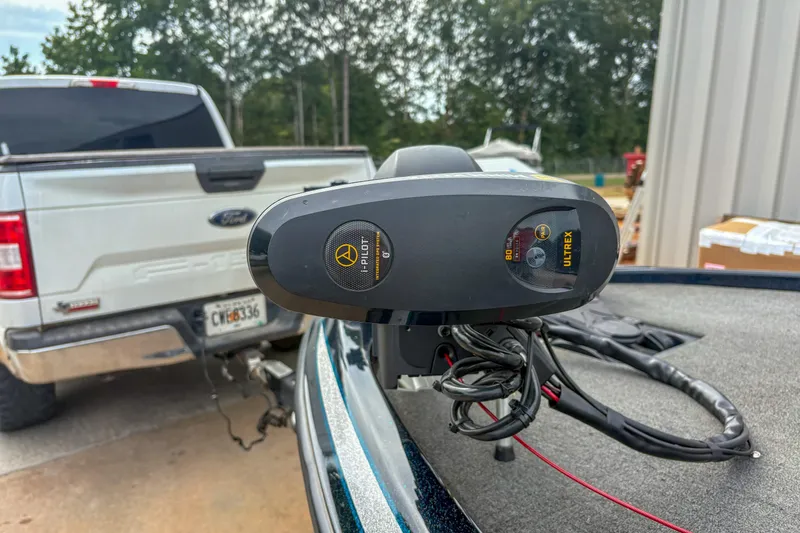 Slide: The Image of 2016 Skeeter ZX200 boat with i-Pilot Ultrex motor, parked near a white truck. - 11