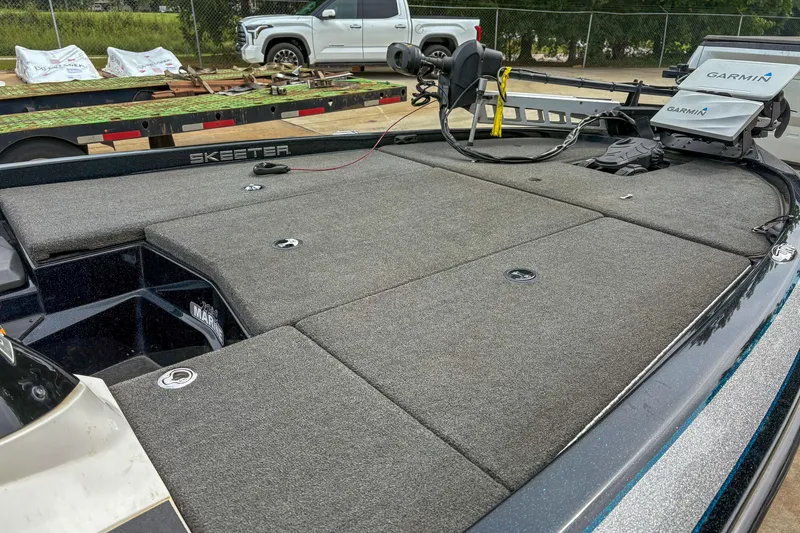 Slide: The Image of 2016 Skeeter ZX200 boat deck with Garmin equipment, parked near a trailer and truck. - 7
