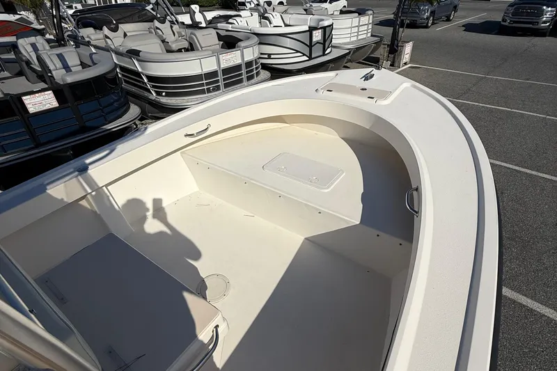 Slide: The Image of 2005 Parker 21 CC boat interior, parked near pontoon boats in a lot. - 14