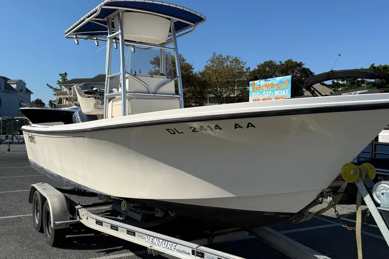 Slide: The Image of 2005 Parker 21 CC boat on trailer in parking lot, clear sky background. - 2