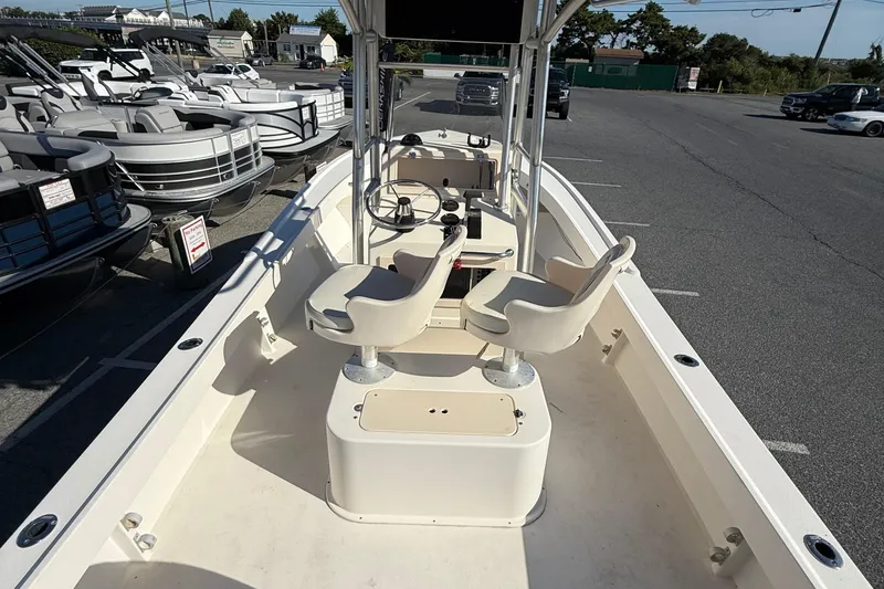 Slide: The Image of 2005 Parker 21 CC boat with dual seats, steering wheel, and console in a marina setting. - 8