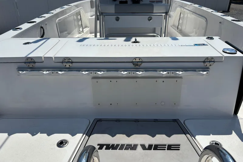 Slide: The Image of 2022 Twin Vee 240 GFX CC boat interior with fishing rod holders and storage. - 10