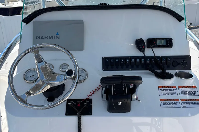 Slide: The Image of 2022 Twin Vee 240 GFX CC boat dashboard with Garmin navigation and Suzuki controls. - 18