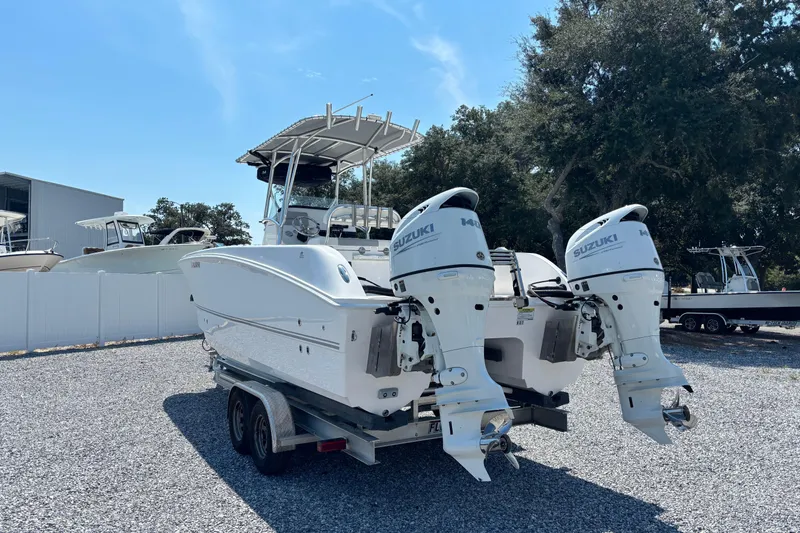 Slide: The Image of 2022 Twin Vee 240 GFX CC boat with dual Suzuki engines on a trailer. - 2