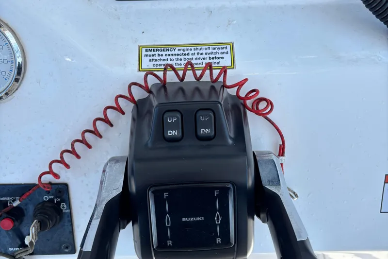 Slide: The Image of Control panel of 2022 Twin Vee 240 GFX CC boat with Suzuki throttle and emergency lanyard. - 21